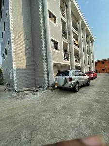 un coche aparcado frente a un gran edificio en Superbe appartement meublé en résidence LBV en Libreville