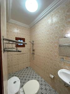 y baño con aseo y lavamanos. en Superbe appartement meublé en résidence LBV en Libreville
