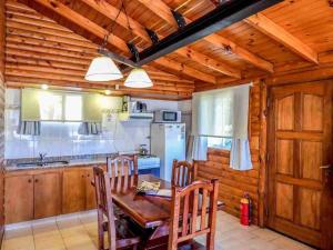 cocina con mesa, sillas y nevera en Balcon del Golf en Sierra de la Ventana