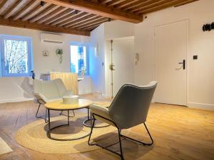 a living room with two chairs and a table at Appartement Clermont-Fd jaude 1 in Clermont-Ferrand +5 photos