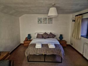 um quarto com uma cama grande e almofadas em the lodge@ beechwood house em Mossley