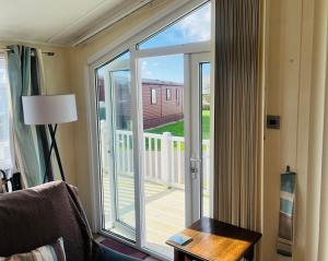 a room with a sliding glass door to a porch at 40A Oak Village- 2 Bedroom Lodge on Grange Leisure Park in Mablethorpe