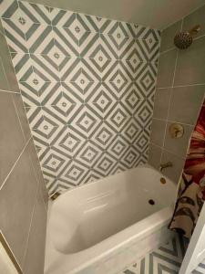 a white tub in a bathroom with a tiled wall at Luv Happii House in Country Club Hills