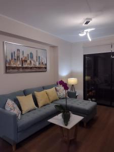 Una sala de estar con un sofá azul y una mesa. en Aparment Deluxe San Isidro, en Lima