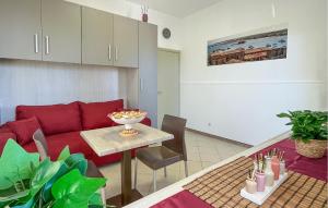 a living room with a red couch and a table at Nice Apartment In Marzamemi in Marzamemi