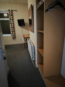 a room with a closet with a desk and a television at The Fountain Hotel in Tuxford