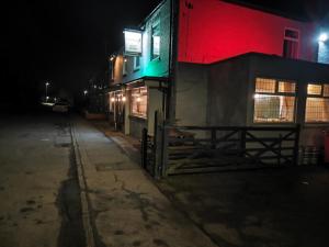 a building with red and green lights on a street at The Fountain Hotel in Tuxford