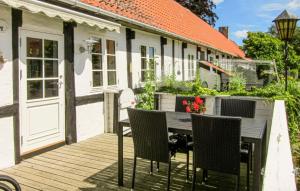 une terrasse en bois avec une table et des chaises sur une maison dans l'établissement Stokrosen, à Åkirkeby