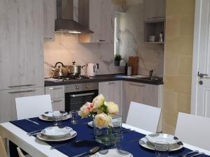 una cocina con una mesa con un jarrón de flores. en Apartment close to the sea, en Marsaskala
