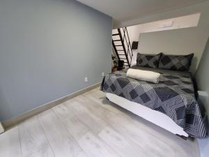 um quarto com uma cama e piso em madeira em LOFT MUNDI - Conforto no Centro com Ar Condicionado em Águas de Lindoia