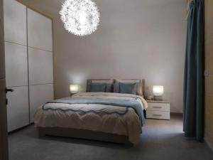 1 dormitorio con cama y lámpara de araña en Apartment close to the sea, en Marsaskala