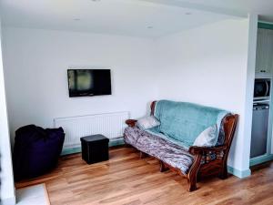 sala de estar con sofá y TV en An Teach Beag Glencolmcille, little home from home, en Glencolumbkille