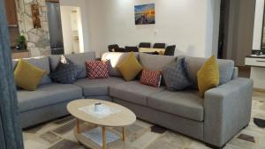 a living room with a gray couch with colorful pillows at Grey house in Samos