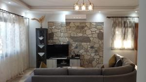 a living room with a couch and a stone wall at Grey house in Samos