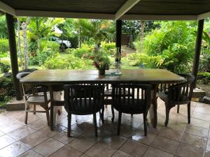 un tavolo e sedie in legno su un patio di Hiti Lodge a Fare (Huahine Nui)