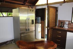 a kitchen with a stainless steel refrigerator and a table at Hiti Lodge in Fare