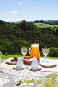 un tavolo con una brocca di succo d'arancia sopra di Hotel Pousada Água Da Mina a Monte Sião