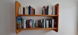 a book shelf filled with books on a wall at Direkter Seezugang am Ossiacher See, Radfahren und Wandern in Villach