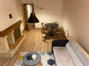 sala de estar con sofá y mesa en Grand appartement, en Chaudes-Aigues
