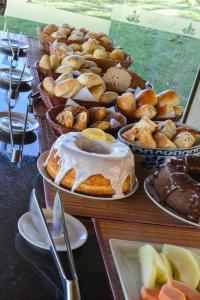 a table filled with different types of pastries and desserts at Hotel Pousada Água Da Mina in Monte Sião
