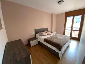 1 dormitorio con 1 cama con 2 almohadas rosas en Apartamento Gold Cadí, en Guardiola de Berguedà