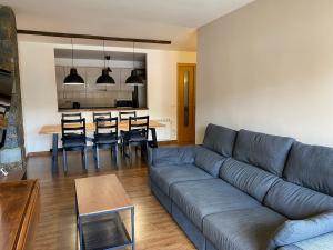 a living room with a couch and a table with chairs at Apartamento Gold Cadí in Guardiola de Berguedà +32 photos
