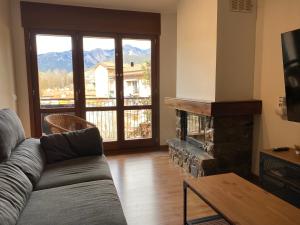 sala de estar con sofá y chimenea en Apartamento Gold Cadí, en Guardiola de Berguedà