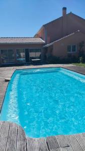 ein großer blauer Pool vor einem Haus in der Unterkunft Maison Moderne Piscine Bordeaux in Pessac