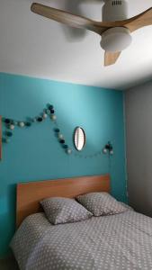 ein blaues Schlafzimmer mit einem Bett und einem Deckenventilator in der Unterkunft Maison Moderne Piscine Bordeaux in Pessac