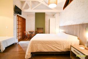 a bedroom with two beds and a dining room at Hotel Pousada Água Da Mina in Monte Sião