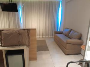 a living room with a couch and a television at BUGAN PAIVA RECIFE in Recife