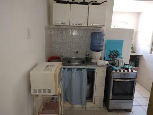uma pequena cozinha com um lavatório e um fogão em APTO mobiliado Candeias, JBO/PE no Recife