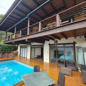 een groot huis met een zwembad en een balkon bij Villa Hermosa in Jarabacoa