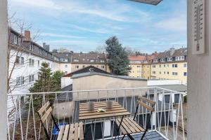 44 Apartments - Modern, Gemütlich, WLAN, Balkon, Stellplatz في فوبرتال: شرفة على مقعد فوق المبنى