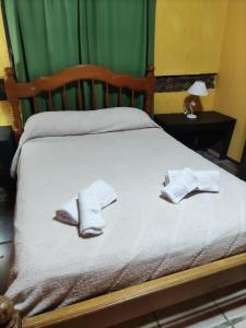a bed with two pairs of socks and shoes on it at La Posada del Norte in La Rioja