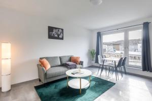 ein Wohnzimmer mit einem Sofa und einem Tisch in der Unterkunft 44 Apartments - Modern, Gemütlich, WLAN, Balkon, Stellplatz in Wuppertal