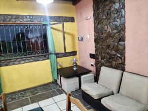 La Posada del Norte في لا ريوخا: غرفة بها أريكة ومغسلة وطاولة