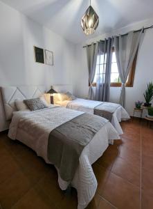 a bedroom with two beds and a chandelier at La Palma Nature in Barlovento