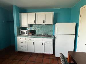 a kitchen with white cabinets and a white refrigerator at Krsna's Castle (Hunt's Castle) in Rockport