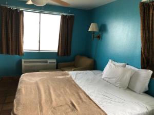 a blue bedroom with a bed and a window at Krsna's Castle (Hunt's Castle) in Rockport