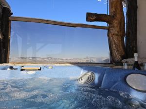 bagno con vasca e ampia finestra di Zerko Holiday Home - Vineyard Chalet With Sauna and Jacuzzi FREE a Mirna