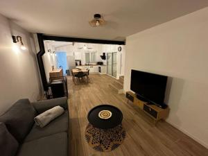 a living room with a couch and a flat screen tv at Villa famille 4 chambres in Chandolas