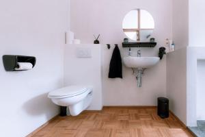 een witte badkamer met een toilet en een wastafel bij Violet Suites in Gent