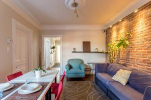 - un salon avec un canapé et un mur en briques dans l'établissement Cozy Montreal Suites in Prime Location, à Montréal