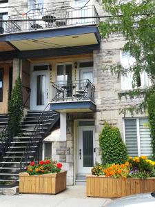 a building with stairs and flowers in front of it at Cozy Montreal Suites in Prime Location in Montreal