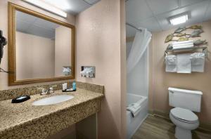 a bathroom with a sink and a toilet and a mirror at Sea Crest Oceanfront Resort in Myrtle Beach