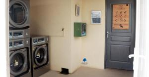 a laundry room with a washing machine and a door at Mobilhome « Destination de vacances» in Sigean