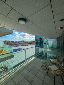 a balcony with chairs and a view of the water at Elegant 2 Bedroom Apartment in Grand Canal in Dublin
