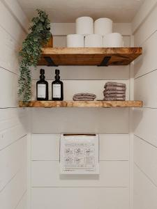 a bathroom with white walls and a shelf with bottles at Shipping Container Home near Fall Creek Falls State Park in Dunlap