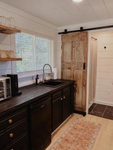 - une cuisine avec un évier et une porte en bois dans l'établissement Shipping Container Home near Fall Creek Falls State Park, à Dunlap